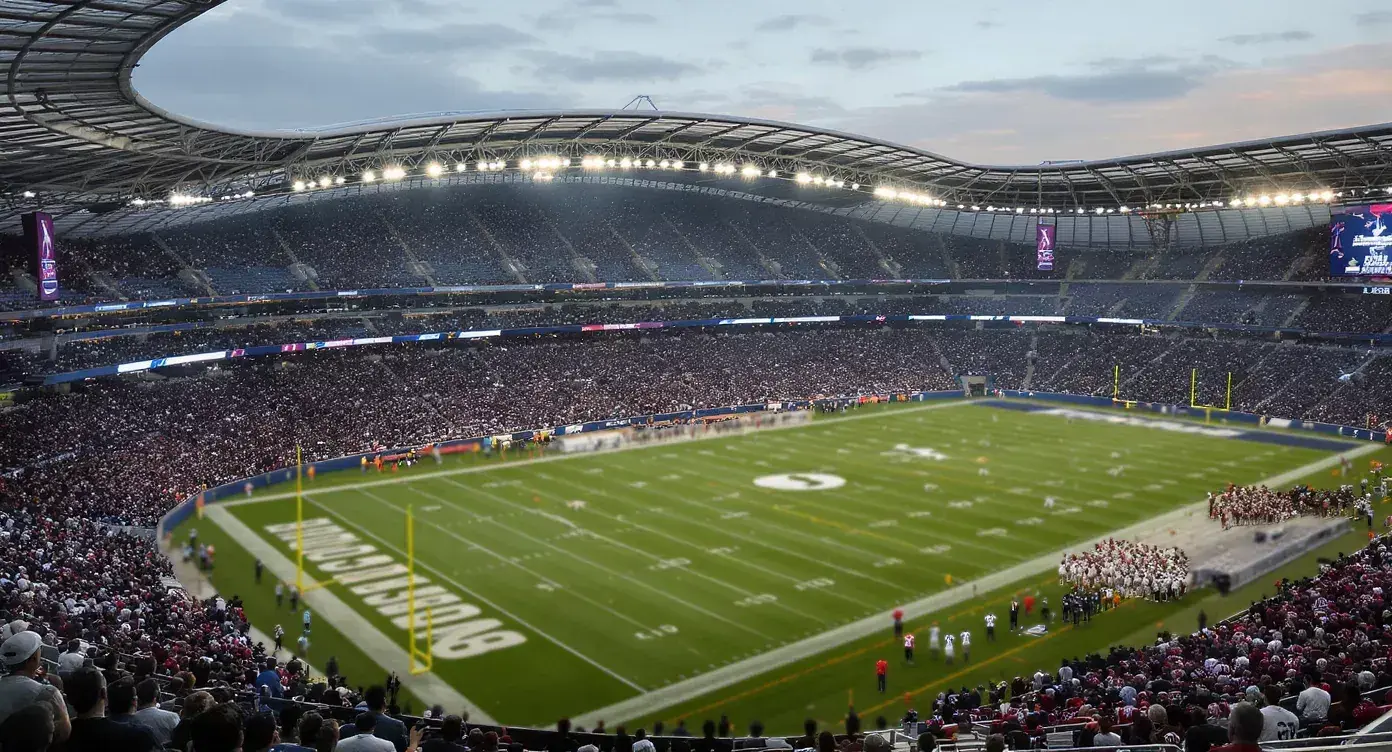 Tottenham Hotspur Stadium pitch viewed from the stands during an NFL London Games kickoff under floodlights